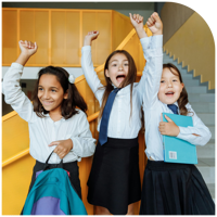 Three students cheering with their arms raised, celebrating on an excursion.
